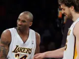 El jugador de los Lakers, Pau Gasol (d) observa el codo de su compañero Kobe Bryant (i).