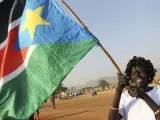 Una mujer ondea una bandera de Sudán del Sur durante el referéndum de autodeterminación.