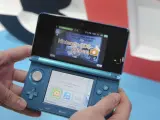 Un hombre muestra la Nintendo 3DS, una consola portátil que muestra imágenes en 3D sin necesidad de gafas.