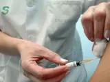 Una enfermera inyecta una vacuna a un paciente.