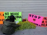 Un manifestante deposita unas flores junto a varias pancartas durante una protesta realiza frente a la empresa Chubu Electric para pedir el cierre de la central nuclear de Hamaoka, en Nagoya (Japón).