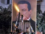 Foto de archivoque muestra a un grupo de manifestantes retirando un cartel con la imagen del expresidente egipcio Hosni Mubarak durante una protesta en Alejandría, Egipto.