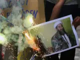 La gente quema una fotografía de Osama bin Laden mientras celebran su muerte en la ciudad occidental india de Ahmedabad.