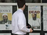 Un hombre pasa ante las portadas de varios periódicos estadounidenses que muestran imágenes de Osama bin Laden en el exterior del Newseum, en Washington (EE UU).
