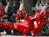 Un gran número de mecánicos mueven el coche del piloto brasileño Felipe Massa. La imagen pertenece a la sesión clasificatoria para el Gran Premio de China de Fórmula 1, en Shanghái.