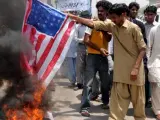 Un grupo de personas queman una bandera estadounidense durante una protesta por la muerte del líder de Al Qaeda, Osama Bin Laden, en Multan (Pakistán).