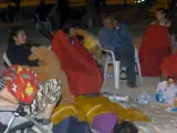 Varias personas se protejen con mantas en el campamento habilitado en el Huerto de la Rueda.