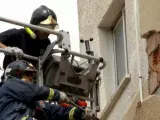 Dos bomberos trabajando en las labores de reparación de los edificios de Lorca.