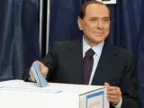 El primer ministro italiano, Silvio Berlusconi, introduciendo su voto en la urna de un colegio electoral de Milán, en la primera vuelta de los comicios municipales.