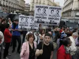 Dos manifestantes en Sol con carteles contra los líderes del PSOE y PP.