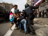 Un agente carga contra un grupo, en el que se encuentra Sebastián Ledesma, en silla de ruedas, durante el desalojo de la Plaza Cataluña en Barcelona.