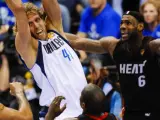 Dirk Nowitzki, ala-pívot de Dallas Mavericks, captura un rebote ante Lebron James y Joel Anthony, de Miami Heat.