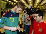 El portero de la selección sub'21, David De Gea, firmando un autógrafo a un aficionado en el aeropuerto de Barajas.