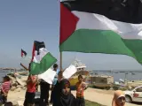 Un grupo de palestinos ondea banderas durante una marcha en apoyo a la flotilla de la libertad, en el puerto de Gaza.