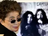 Yoko Ono, viuda de Lennon, sonríe frente a una foto que muestra al ex beatle y a ella durante el 22º aniversario de la muerte del cantante.