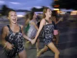 Unas jóvenes corren hacia uno de los cinciertos del Festival Internacional de Benicassim 2011 (FIB) en la jornada de apertura.