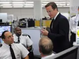 El primer ministro británico, David Cameron (segundo por la derecha), conversa con oficiales del departamento de bomberos londinense durante una visita al cuartel general del 'Comando Oro' de la Policía Metropolitana en Lambeth, sur de Londres (Reino Unido).
