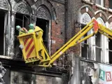 Trabajadores miran una casa quemada durante las protestas en Clapham, Londres