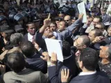 Abogados egipcios de la acusación contra Hosni Mubarak protestan ante las puertas de la sala donde se celebra el juicio contra el expresidente de Egipto, tras impedirles las fuerzas de seguridad el acceso a la vista.