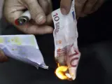 Manifestantes griegos queman billetes de euro ante la sede del Banco de Grecia.