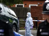 Los policías examinan un coche cerca de una casa donde se practicaron arrestos en Birmingham.