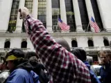 Un grupo de jóvenes se manifiesta ante la sede de la bolsa de Nueva York, en protesta contra el sistema económico.