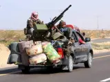 Un grupo de rebeldes libios circula en una furgoneta armada con una ametralladora, por la carretera entre Bin Jwad y Sirte, Libia.
