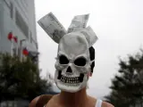 Un activista lleva una máscara con nuevos dólares de Taiwán mientras participa en la protesta global del 15-O en Taipei.