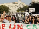 Variedad de personas asisten a la marcha de Madrid del 15-O, todos bajo una pancarta que reza: "Unidos por un cambio global".
