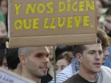 Un joven muestra una pancarta durante la manifestación de miles de 'indignados' por las calles de Valladolid.
