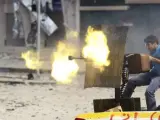 Rebeldes libios disparan una ametralladora montada en una camioneta, durante los combates que se libran en la ciudad de Sirte.
