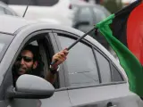 Un hombre ondea la bandera nacional por la ventanilla de su coche mientras celebra la liberación de Libia.