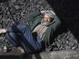 Un afgano descansa sobre el carbón que vende de cara a la llegada del frío, en Kabul, Afganistán.