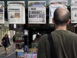 Un ciudadano griego observa las portadas de los diarios en un quiosco en el centro de Atenas.