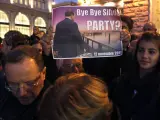 Un hombre sostiene una pancarta que reza "Adiós, Silvio" ("Bye bye, Silvio"), junto al palacio Chigi de Roma.