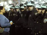 Una mujer mira fijamente a los policías durante el desalojo de los 'indignados' de Nueva York del movimiento 'Occupy Wall Street' que acamparon en el parque Zuccotti.