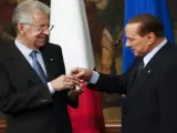 El nuevo primer ministro Mario Monti recibe de su predecesor Silvio Berlusconi una campanilla de plata como símbolo del traspaso de poderes.