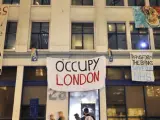 Los 'indignados' de Londres despliegan pancartas en la fachada de un bloque de oficinas vacío del banco UBS en el barrio de Hackney, en el este de la capital.