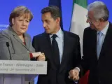 Angela Merkel, Nicolas Sarkozy y Mario Monti estrechan manos al final de un congreso sobre la crisis en la eurozona.