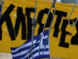 Cuatro cuerdas de horcas frente a una bandera griega y una pancarta que dice "ladrones", durante una protesta en la plaza Syntagma, junto al edificio del Parlamento en Atenas, Grecia.
