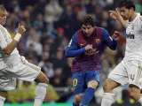 Leo Messi pasa el balón ante Xabi Alonso y Pepe durante el Real Madrid - Barça.