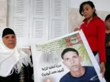 La madre de Mohamed Bouazizi, Manoubia, sostiene un cartel, junto con sus hijas Samia y Besma, de su hijo, cuya inmolación prendió la mecha de la 'Primavera Árabe'.