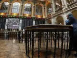 Interior del palacio de la Bolsa española en el que varias personas observan las pantallas de contratación.