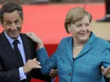 Gesto cariñoso entre los líderes Nicolas Sarkozy y Angela Merkel.