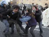 Un joven es arrestado por unos agentes de la policía italiana mientras dos chicas tratan de impedirlo en la plaza de San Pedro del Vaticano durante un acto de protesta en contra la reunión del papa Benedicto XVI con el primer ministro italiano, Mario Monti.