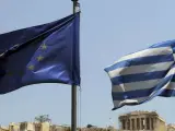 Las banderas de Grecia y de la Unión Europea en frente de la Acrópolis en Atenas.