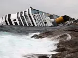 Las olas chocan contra las rocas cerca del buque crucero Costa Concordia.