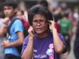 Una mujer intenta llamar desde el móvil en Cebu (Filipinas) tras un terremoto de 6,7 en la escala Ritcher.