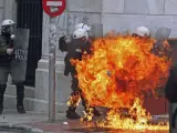 Policías antidisturbios griegos envueltos en llamas por los cócteles molotov lanzados por manifestantes.