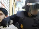 La policia custodia a un detenido durante los incidentes entre estudiantes y policias registrados en el centro de Valencia.